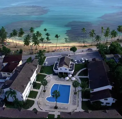 an aerial view of a resort with a swimming pool and the ocean at Beachfront apartment in Las Terrenas