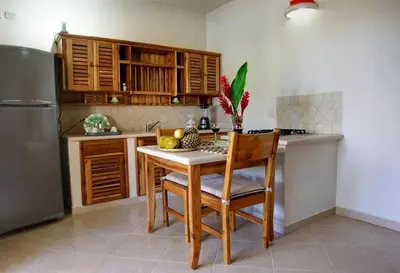 a kitchen with a table and chairs and a refrigerator at Beachfront apartment in Las Terrenas