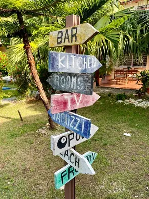 a street sign with arrows pointing in different directions at 21 Palms in Las Galeras