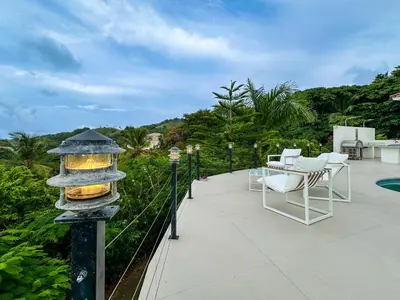 a patio with a table and chairs and a lantern at Villa Playa Colorada Eco-Luxury Beachfront Retreat in La Colmena