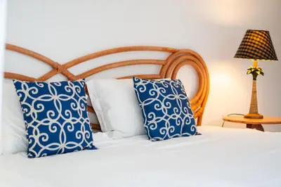 a bed with blue and white pillows and a lamp at Villa Playa Colorada Eco-Luxury Beachfront Retreat in La Colmena