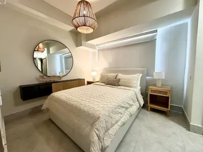 a bedroom with a large bed and a mirror at Paradises Room in Boca Chica