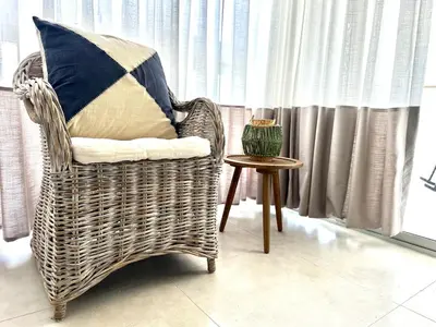 a wicker chair with a pillow and a table at Paradises Room in Boca Chica