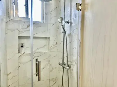 a shower with a glass door in a bathroom at Paradises Room in Boca Chica