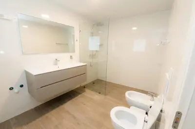 a bathroom with a toilet and a sink and a mirror at TRACADERO Ocean Pearl Suite in La Laguna