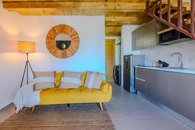 a living room with a yellow couch in a kitchen at Esprit Caribbean Bayahibe by Caribbean Paradise Rentals in Bayahibe