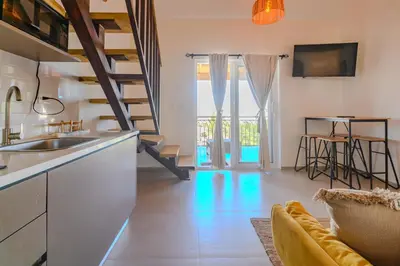 a kitchen with a sink and a living room at Esprit Caribbean Bayahibe by Caribbean Paradise Rentals in Bayahibe