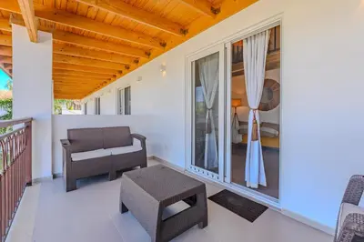 a porch with a chair and a table at Esprit Caribbean Bayahibe by Caribbean Paradise Rentals in Bayahibe