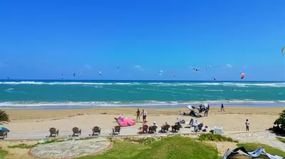 a group of people sitting on the beach at Agualina Kite Hotel in Cabarete
