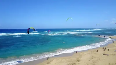 a group of people flying kites on the beach at Agualina Kite Hotel in Cabarete