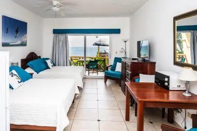 a hotel room with two beds and a table at Agualina Kite Hotel in Cabarete
