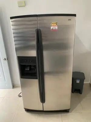 a stainless steel refrigerator with a microwave in a kitchen at Seaside Elegance in Baní