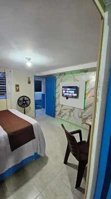 a bedroom with a bed and a tv on a wall at Nido de amor in Jarabacoa