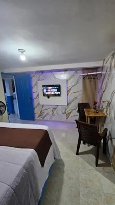 a bedroom with a bed and a tv on a wall at Nido de amor in Jarabacoa