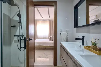 a bathroom with a shower and a sink and a mirror at Lovely 3 Bedroom Apartment, Pool,Gym,2parking S in Santo Domingo