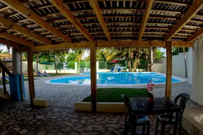 a patio with a table and chairs and a swimming pool at Hotel la Saladilla Beach Club in Santa Cruz de Barahona