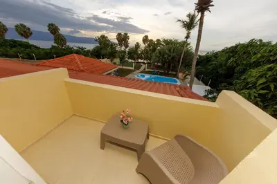 a balcony with a table and chairs and a pool at Hotel la Saladilla Beach Club in Santa Cruz de Barahona
