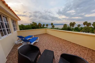 a balcony with chairs and a view of the ocean at Hotel la Saladilla Beach Club in Santa Cruz de Barahona