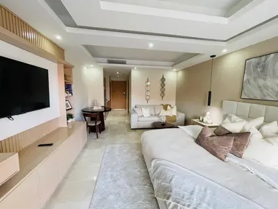 a living room with a large white couch and a tv at Marien Residences 305 Deluxe High Floor Condo in Puerto Plata
