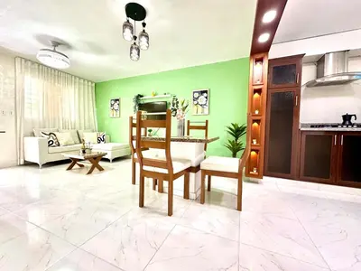 a living room with green walls and a table and chairs at Vista Central in Colorado