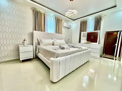 a white bedroom with a large bed and a television at Casa Elegante in Colorado
