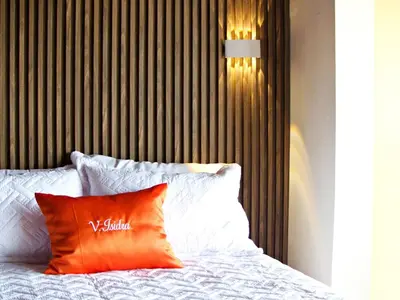 a bed with an orange pillow on top of it at Luperon Cerca del Mar in Colorado