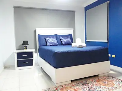 a blue bedroom with a bed and a night stand at Cofresi, Puerto Plata in Colorado