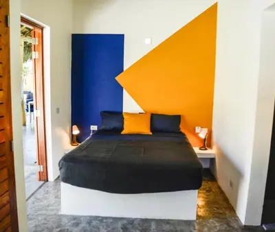 a bedroom with a bed with an orange and blue wall at Nomadas 5 bdrs villa with private pool 2nd line to beach in Las Terrenas