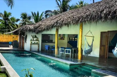 a house with a swimming pool in front of a building at Nomadas 5 bdrs villa with private pool 2nd line to beach in Las Terrenas