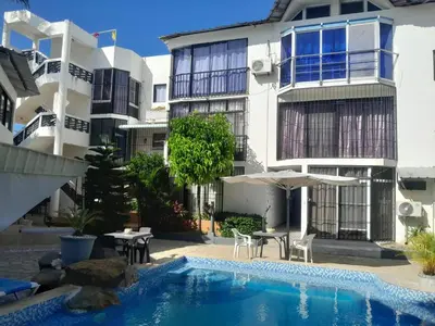 a hotel with a swimming pool in front of a building at One bedroom apartment in the center with a pool in Sosúa