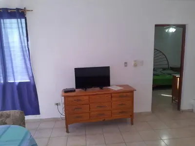 a tv on a wooden dresser in a room at One bedroom apartment in the center with a pool in Sosúa