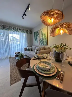 a living room with a table and a couch at Garden Breeze Ghibli-Pool View in La Laguna