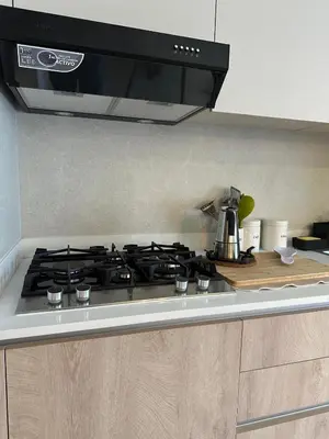 a kitchen with a stove top in a kitchen at Garden Breeze Ghibli-Pool View in La Laguna