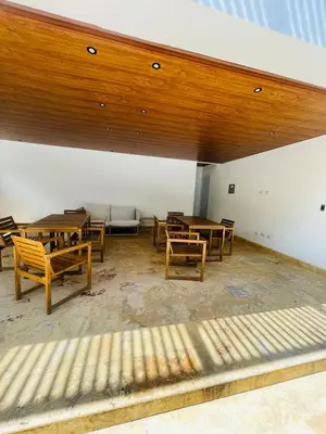 an empty room with wooden tables and chairs at Sunset Residences 3BR, Pool & Beach Cosita Rica in Puerto Plata