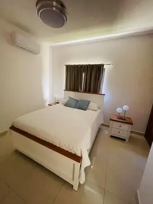a bedroom with a white bed and a window at Sunset Residences 3BR, Pool & Beach Cosita Rica in Puerto Plata