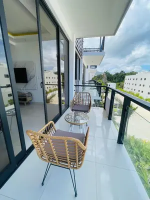 a balcony with two chairs and a table at Sunset Residences 3BR, Pool & Beach Cosita Rica in Puerto Plata