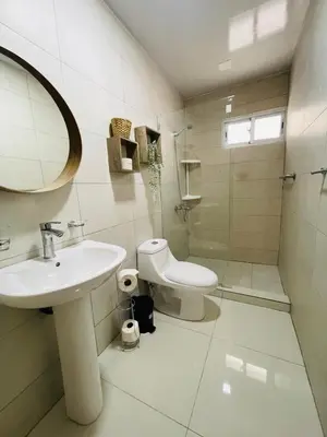 a white bathroom with a sink and a toilet at Oasis Residences, Modern 3BR Apartment with Pool in San Felipe de Puerto Plata