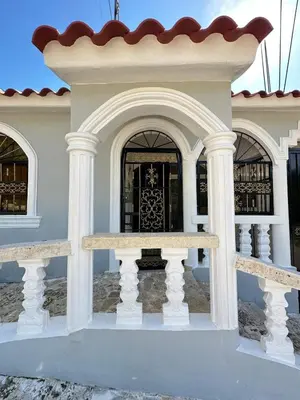 a house with white columns and a gate at Modern and fully equipped house in Samaná in Santa Bárbara de Samaná