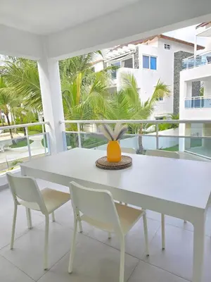 a white table and chairs on a balcony with palm trees at Estrella Condos 8min walk to the beach Studio 201A in La Laguna