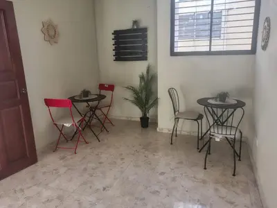 a room with two tables and chairs and a plant at La Guarida de Mela in Santo Domingo
