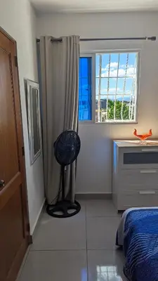 a bedroom with a bed and a window and a chair at Mitaly Apartamentos 111 in Santo Domingo