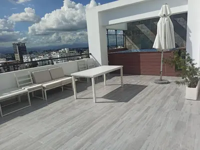 a balcony with a table and benches on a roof at Elegant Downtown Stay Santo Domingo in Santo Domingo