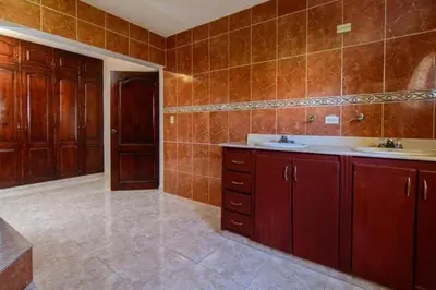 a bathroom with wooden cabinets and a sink at 4BR Villa Newly Renovated-5 min to Playa Dorada H1 in San Felipe de Puerto Plata