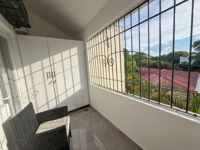 a balcony with two chairs and a large window at Stylish Sosua 2 BR apartment near everything in Sosúa