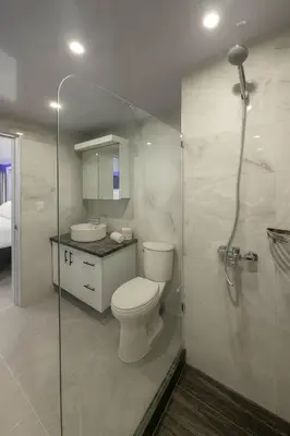 a bathroom with a toilet and a glass shower at Stylish Sosua 2 BR apartment near everything in Sosúa
