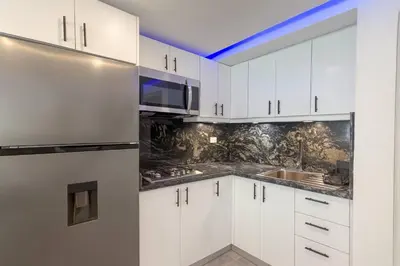 a kitchen with white cabinets and a microwave at Stylish Sosua 2 BR apartment near everything in Sosúa