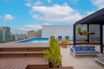 a rooftop patio with a swimming pool on a building at Upscale City Center Condo, Pool, Gym in Santo Domingo