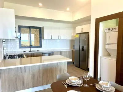 a kitchen with white cabinets and a table with glasses on it at Chic 2BR Apt 1km from Playa Bonita in Las Terrenas