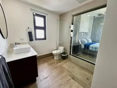 a bathroom with a sink and a toilet and a mirror at Chic 2BR Apt 1km from Playa Bonita in Las Terrenas