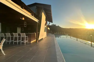 a house with a swimming pool with chairs and the sunset at Chic 2BR Apt 1km from Playa Bonita in Las Terrenas